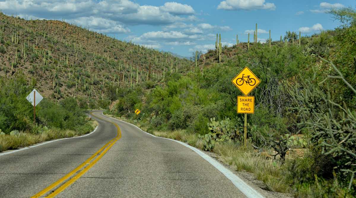 share the road with bicycles sign on empty road in arizona